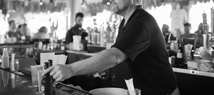man bartender giving a beer to patron