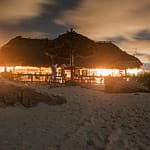 tiki bar at night taken from sand