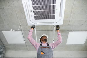 Professional technician servicing an air conditioning unit, offering benefits of professional HVAC installation in Hillsborough County.