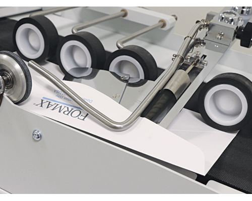Precision moistening roller and flap feeding plate accurately seal both stacked and nested envelopes
